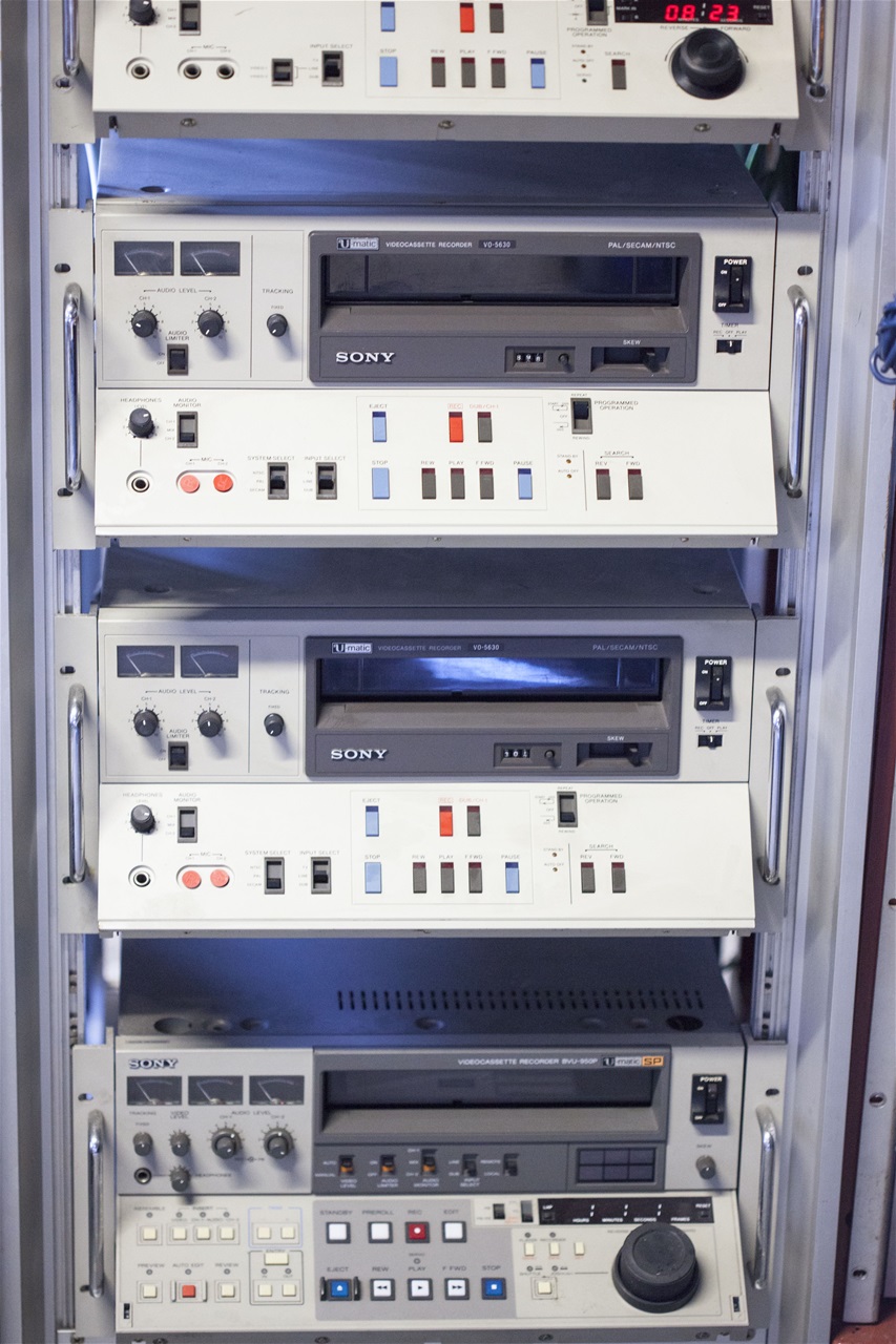 Rack in studio w Umatic video recorders.
The BVU-950 Editing U-matic incorporates Sony's Superior Performance (SP) technology, to offer higher picture quality and dubbing capability, while remaining compatible with ealier high-band U-matics.
It also features a plug-in wide window time base corrector and time code generator/reader options. It was one of the first VTRs to use the search dial for setting and displaying time code diagnostics, VTR functions and much more.
Improved audio performance is guaranteed by adoption of Dolby C noise reduction for SP tapes, with auto-detection/activation on playback.

Improved design makes unit lighter than predecessors.
FM carrier frequency 0.8MHz up on normal high-band, improves luminance resolution to 300 lines for clear, detailed colour/monochrome playback.
Fully compatible with high band U-matics in luminance signal deviation (1.6MHz) and chroma sub-carrier frequence (924kHz).
Takes low/high band and SP tapes, with built in auto selection of system and Dolby in/out detection when using Sony KSP tapes.
Improved video circuitary improves luminance/chrominance ringing performance.
Dolby C noise reduction improves audio signal-to-noise ratio to 72dB (measured by CCIR/ARM filter, RMS).
heads and playback circuit improve audio frequency response and raise non-Dolby signal-to-noise ratio to 52dB in SP mode.
Improved controls for audio/erase/record/playback heads improve audio insert editing accuracy.
First-ever plug-in time base correction available with optional BKU-903, a full-feature wide window TBC with seperate remote controller.
Optional BKU-905 plug-in time code generator/reader permits sophisticated time code editing.
Dial operated setting and LED/monitor display of codes, diagnostics, preroll and operational data, with built in character generator.
Built in 2-machine editing facility with RS-422 remote control interface.
Bidirectional shuttle/jog options giving quality pictures from STILL to 10 times normal or frame by frame.